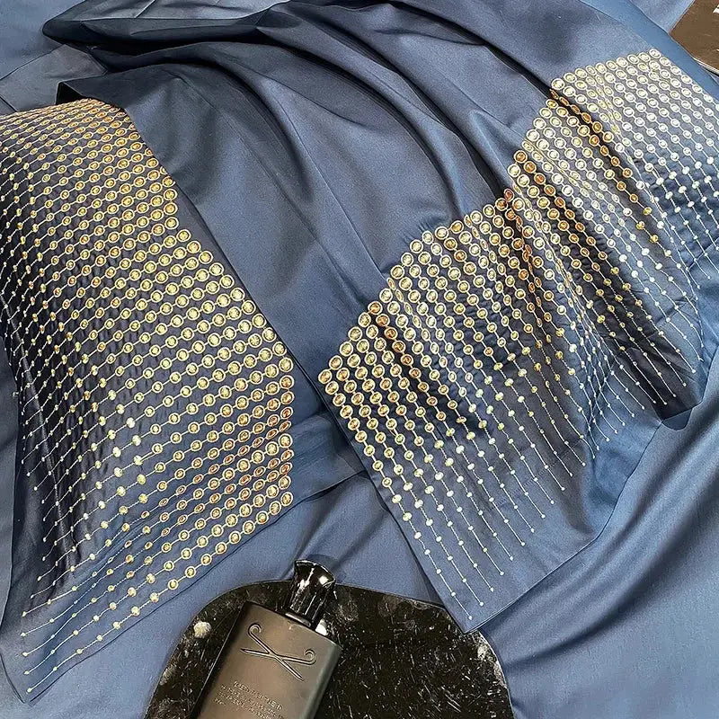 A navy blue satin scarf with gold and silver sequins complements the luxury blue and champagne decorbites 1000tc cotton embroidery bedding set