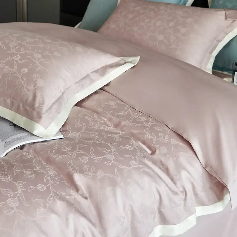 Luxury blush pink satin duvet cover set with delicate white floral embroidery and cream piping for bedroom bedding