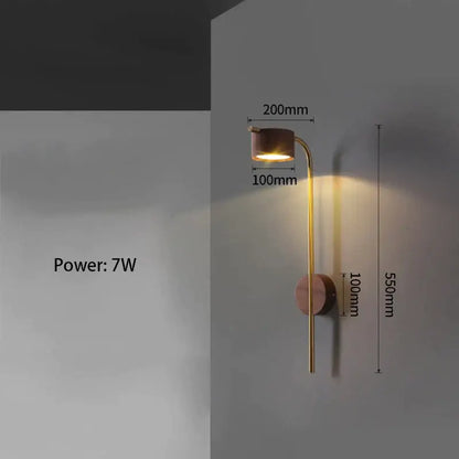 A sleek brass wall lamp with black walnut wood base and curved arm emitting warm light for bedroom reading