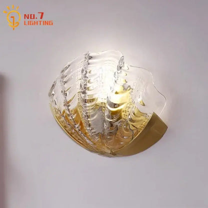 Luxury brass glass shell wall lamp with a translucent textured glass shade and gold-toned metal base for bedroom decorbites brass glass