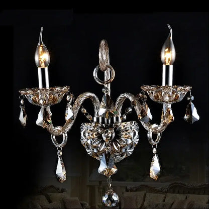 Elegant decorbites clear crystal wall lamp with silver-toned metal arms and three candle-style bulbs for bedroom decor