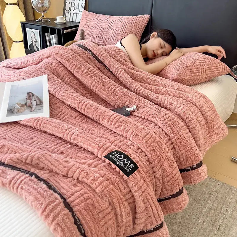 Luxury coral fleece pink plush fleece blanket with textured woven pattern and black trim for winter bedroom use