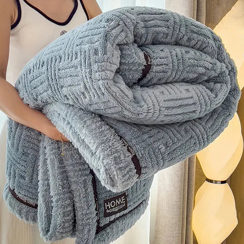 Luxury coral fleece winter blanket in light gray with textured woven pattern and dark brown trim for bedroom use