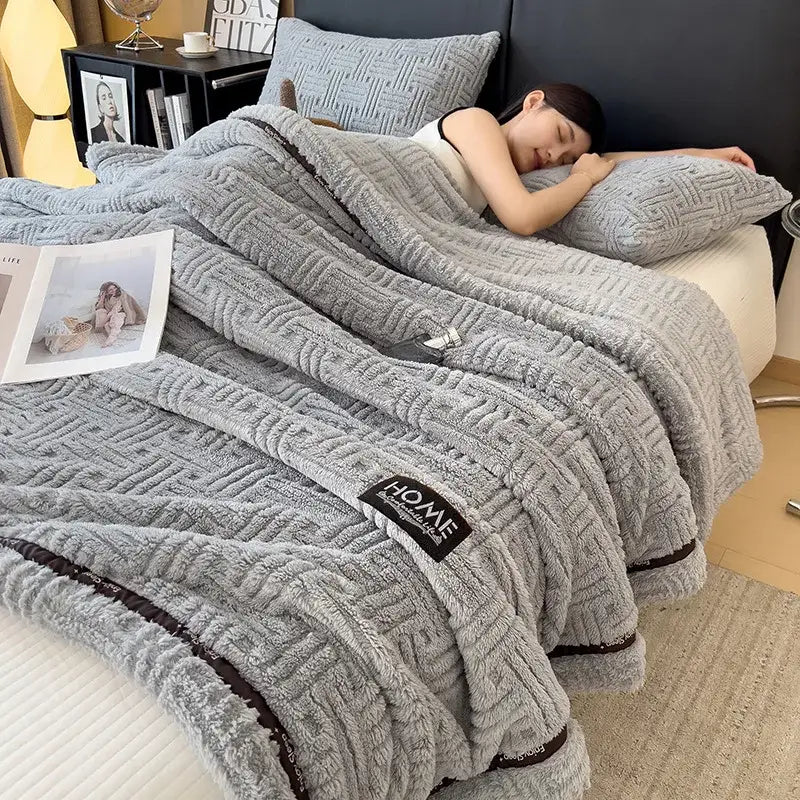Luxury coral fleece gray winter blanket with textured woven pattern and dark brown trim featuring black brand label