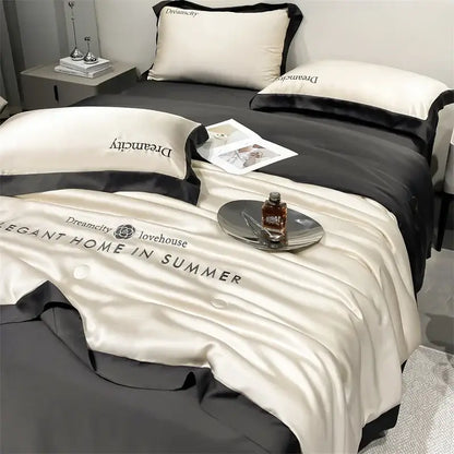Luxury cream and black ice silk embroidered quilt set featuring a cream satin duvet cover with black trim and dreamcity branding