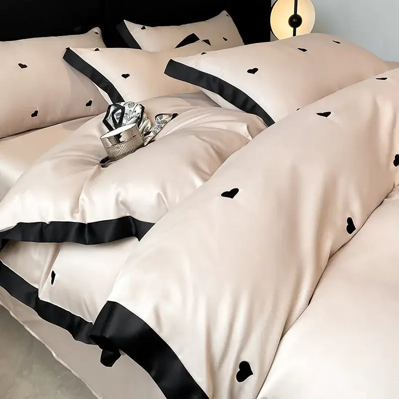 Luxury cream satin bedding set with black heart embroidery and black trim made from decorbites ice silk material