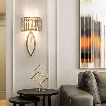 Luxury crystal gold wall lamp with gold-toned base and cylindrical crystal shade by decorbites for living room lighting