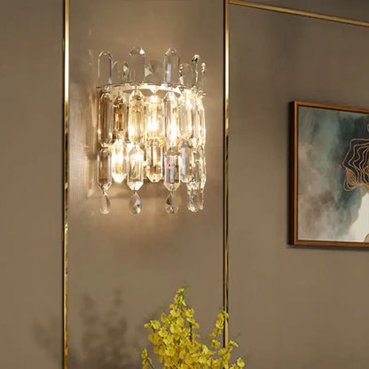 A luxury crystal wall lamp with gold-toned metal frame and cascading clear faceted glass prisms for elegant decorbites crystal wall lighting