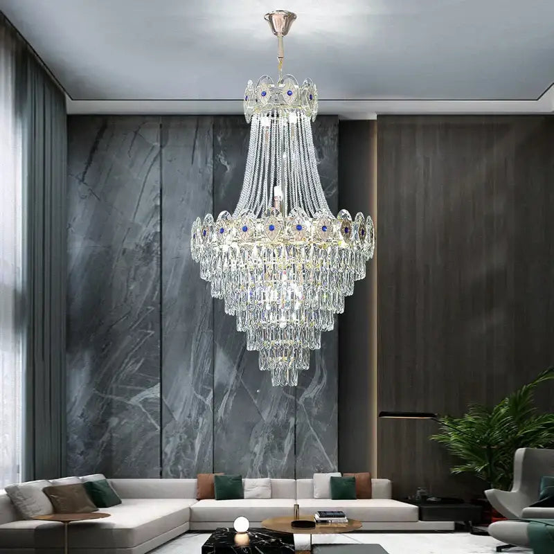A decorbites gold round multi-tiered chandelier with cascading blue crystal strands and polished brass fixture