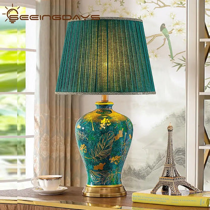 Luxury emerald queen green ceramic table lamp with a teal and gold floral base and pleated green fabric shade for bedroom lighting