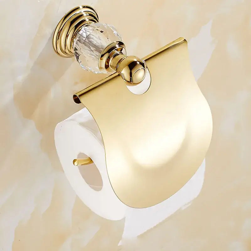 Luxury gold and crystal bath hardware set featuring a gold-toned toilet paper holder with sleek modern design