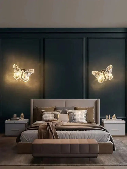 Two illuminated luxury gold butterfly wall lamps with crystalline design emitting warm glow for bedroom lighting