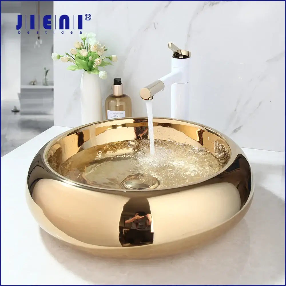 Gold-colored glossy ceramic vessel sink with modern design paired with luxury bath mixer set for bathroom use