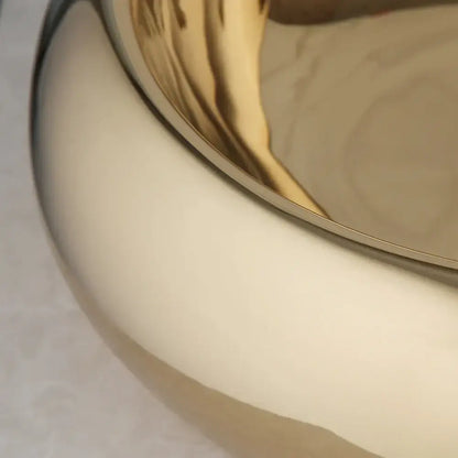 Luxury gold ceramic vessel sink with a sleek curved design and gold-toned bath mixer set for bathrooms
