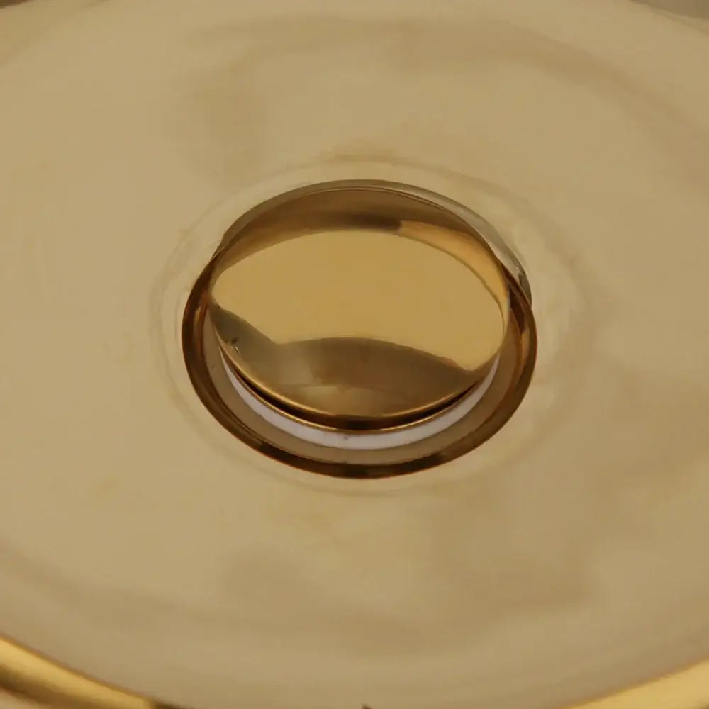 Luxury gold ceramic vessel sink bath mixer set featuring a gold-toned circular flush-mount metallic sink drain