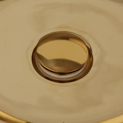 Luxury gold ceramic vessel sink bath mixer set featuring a gold-toned circular flush-mount metallic sink drain