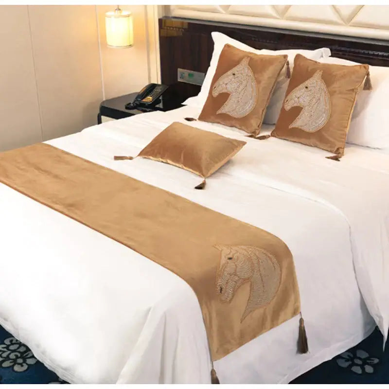 Gold-colored velvet bed runner with embroidered horse heads and tassels complements decorbites gold rhinestone pillow