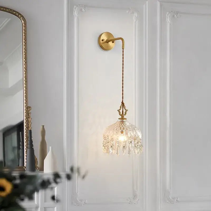 Gold-toned wall sconce with decorbites crystal glass led chandelier-style shade and twisted cord for luxury stair light decor