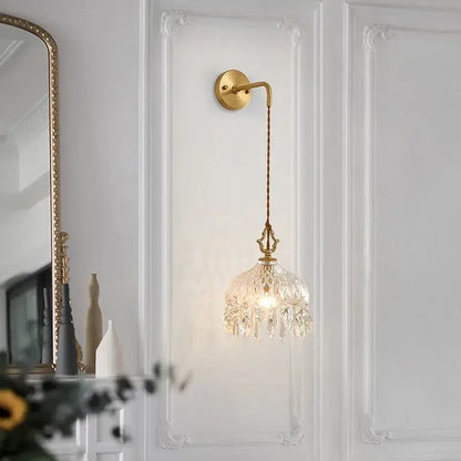 Gold-toned wall sconce with decorbites crystal glass led chandelier-style shade and twisted cord for luxury stair light decor
