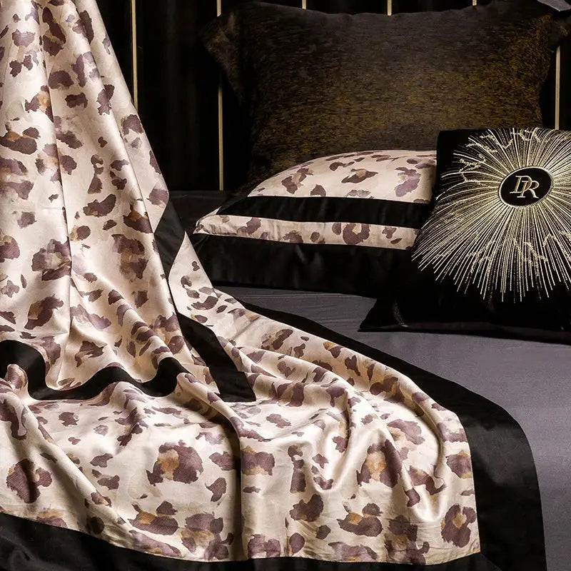 Cream-colored satin bed runner with brown and gold decorbites leopard print edged in black for luxury bedding set