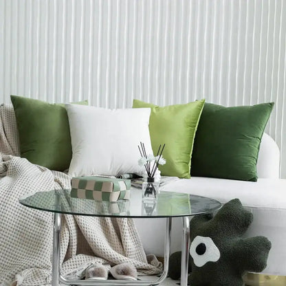 A sleek glass-top coffee table with chrome legs paired with luxury olive green decorbites green velvet pillow case