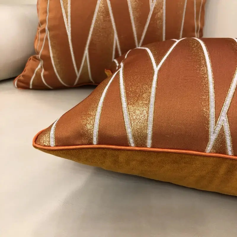 Luxury cushion cover with copper tone and white gold geometric embroidery made from silver quilted jacquard fabric