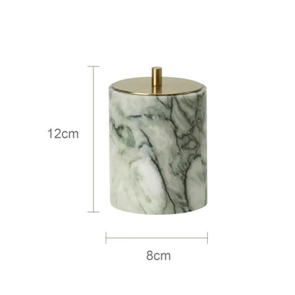 A green and white marble patterned ceramic jar with a gold lid from a luxury emerald marble bathroom set