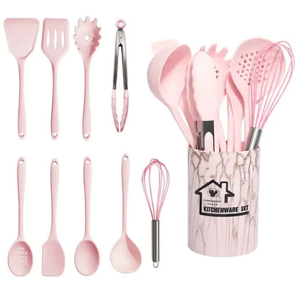 Pink silicone cooking tool set with stainless steel accents in a marble-patterned kitchen storage container