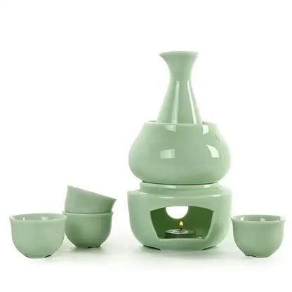 A sleek pale green decorbites ceramic sake set with tiered heater and matching cups in matte black and light blue kit
