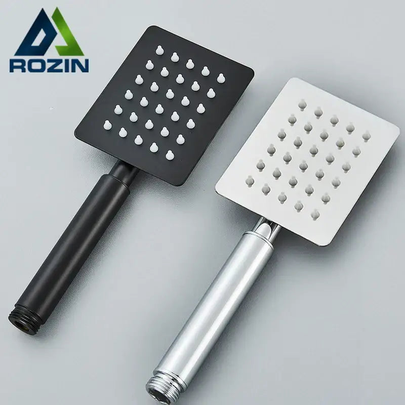 Two square stainless steel handheld shower heads in matte black and brushed silver finish for bathroom use