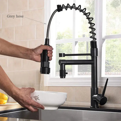Matte black decorbites brass kitchen faucet with swivel spout and coiled spring hose in a modern design