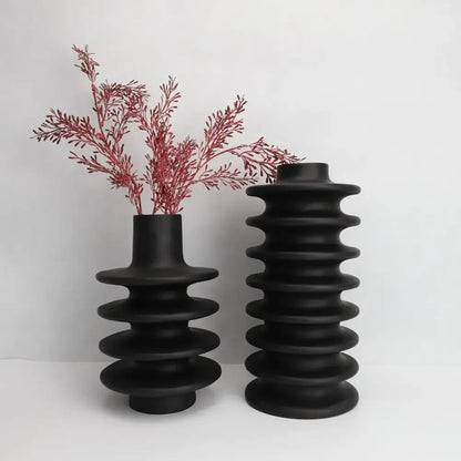 Two matte black ceramic vases with a geometric circle spiral design and narrow neck for living room decor