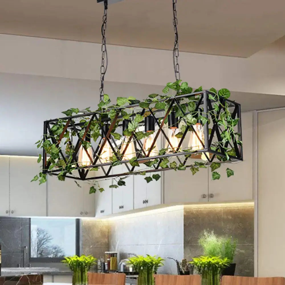 Black metal industrial-style antique black rectangular metal island pendant with exposed filament bulbs and hanging green ivy