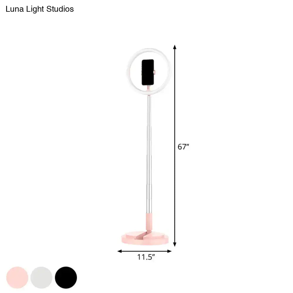 A 67-inch metallic black led makeup lamp with circular led halo and phone holder for bedroom use