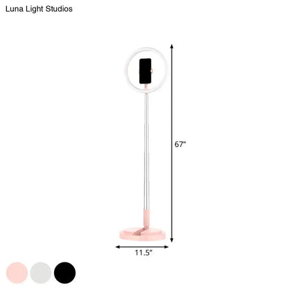 A 67-inch metallic black led makeup lamp with circular led halo and phone holder for bedroom use