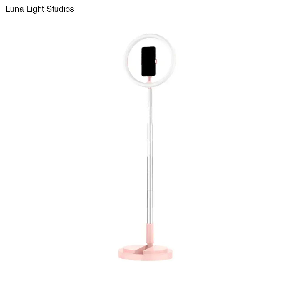 A sleek pink and silver led makeup lamp with collapsible pole and phone holder for bedroom use