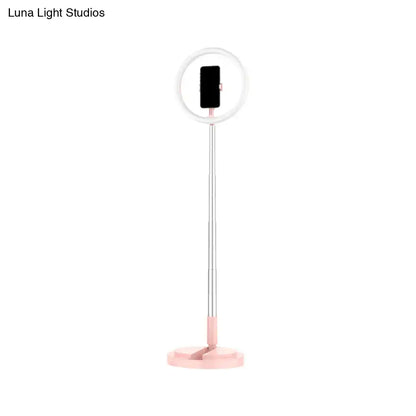 A sleek pink and silver led makeup lamp with collapsible pole and phone holder for bedroom use