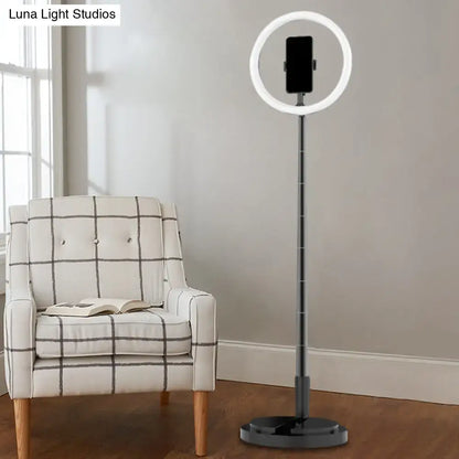 Metallic black led makeup lamp with phone holder featuring a sleek ring light on an adjustable stand for bedroom use