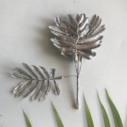 Metallic silver eucalyptus leaf wall decor with intricate detailing and slender stem for living room display