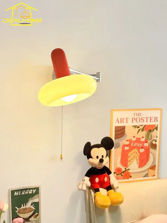 A cheerful red and yellow Mickey Mouse-themed cream wind wall lamp with a rounded glowing shade for bedroom reading light