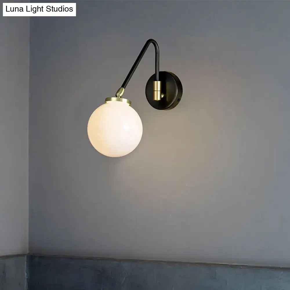 A sleek black mid century wall sconce with brass accents and frosted opal glass shade for e26 e27 bulbs