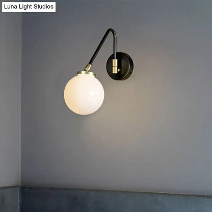 A sleek black mid century wall sconce with brass accents and frosted opal glass shade for e26 e27 bulbs