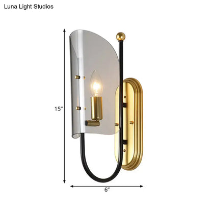 A mid century wall mount lamp with brushed brass, black metal arm, and smoke grey glass shade for hall wall lighting