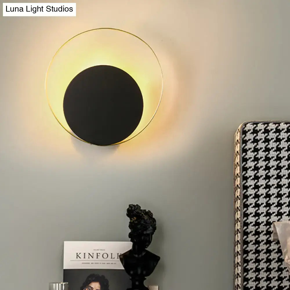 Modern mid century black and gold circle sconce with sleek black center and gold outer ring for bedroom wall lighting