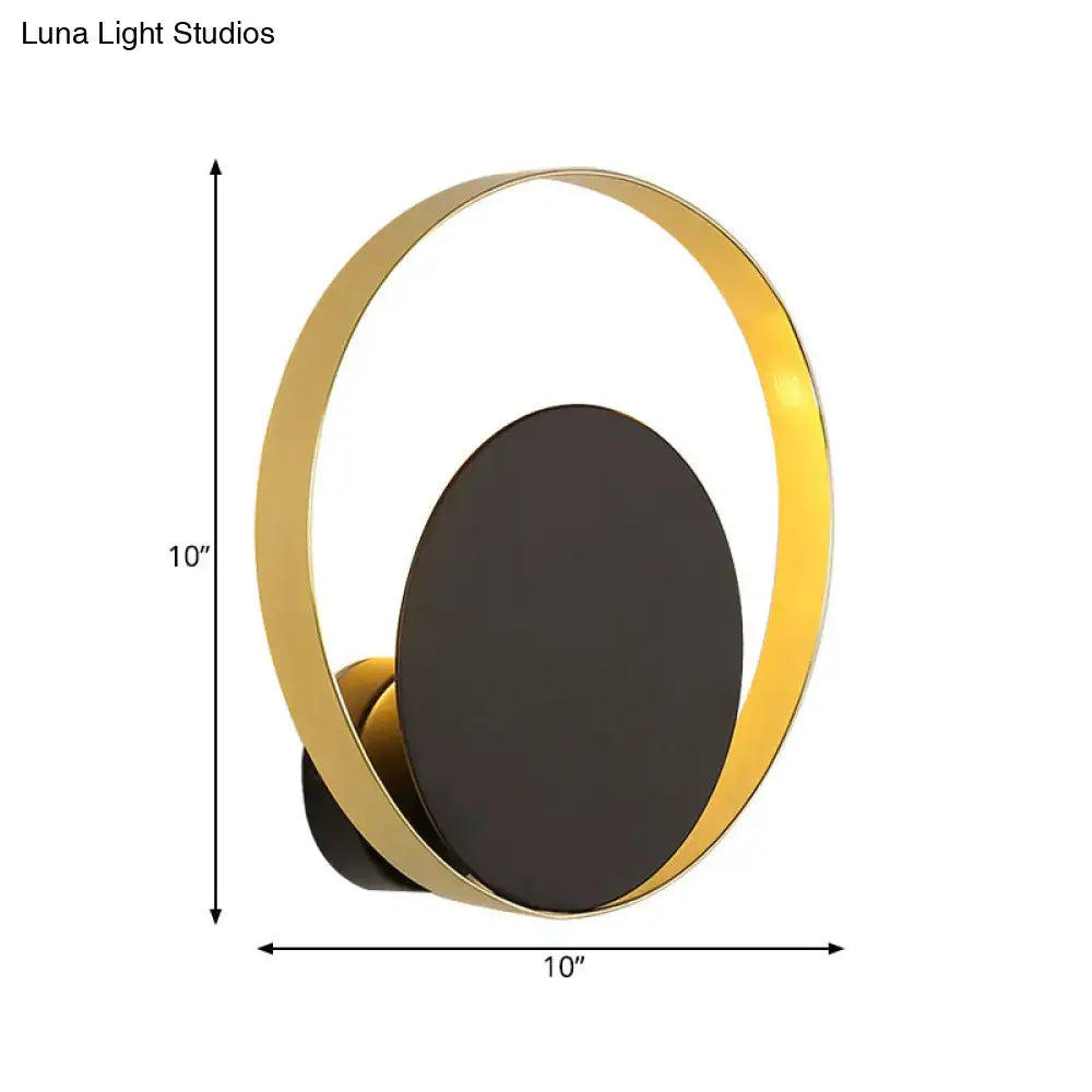 Mid century black and gold circle sconce with gold-toned circular light and matte black oval panel for bedroom wall lighting