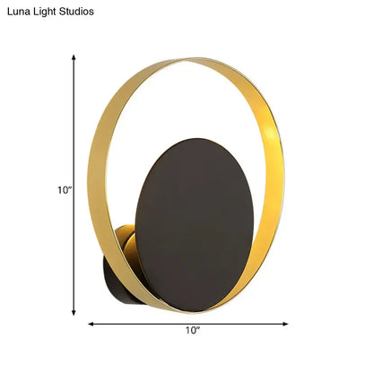 Mid century black and gold circle sconce with gold-toned circular light and matte black oval panel for bedroom wall lighting