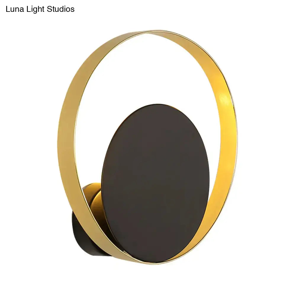 Mid century black and gold circle sconce with gold toned circular light and matte black oval panel for bedroom wall lighting