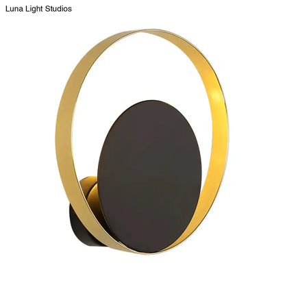 Mid century black and gold circle sconce with gold toned circular light and matte black oval panel for bedroom wall lighting