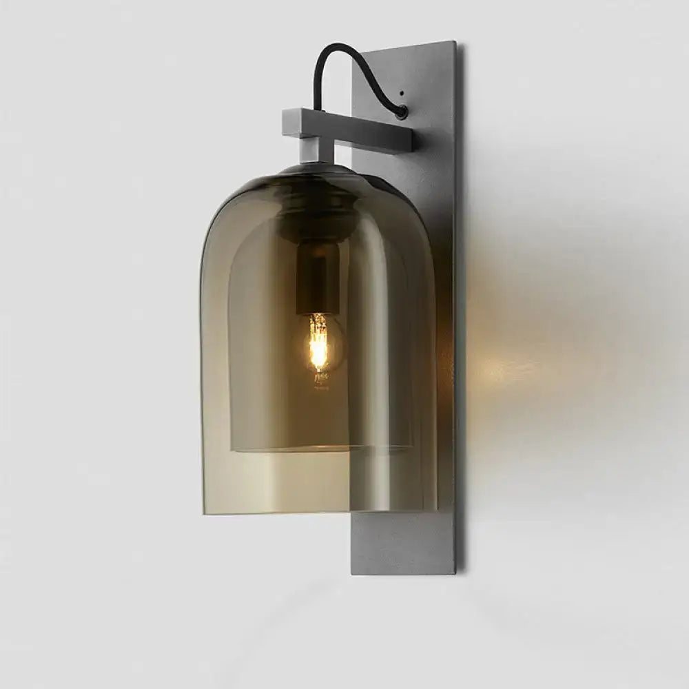 Mid-century black wall sconce with matte black metal frame and smoked dome glass shade for living room use