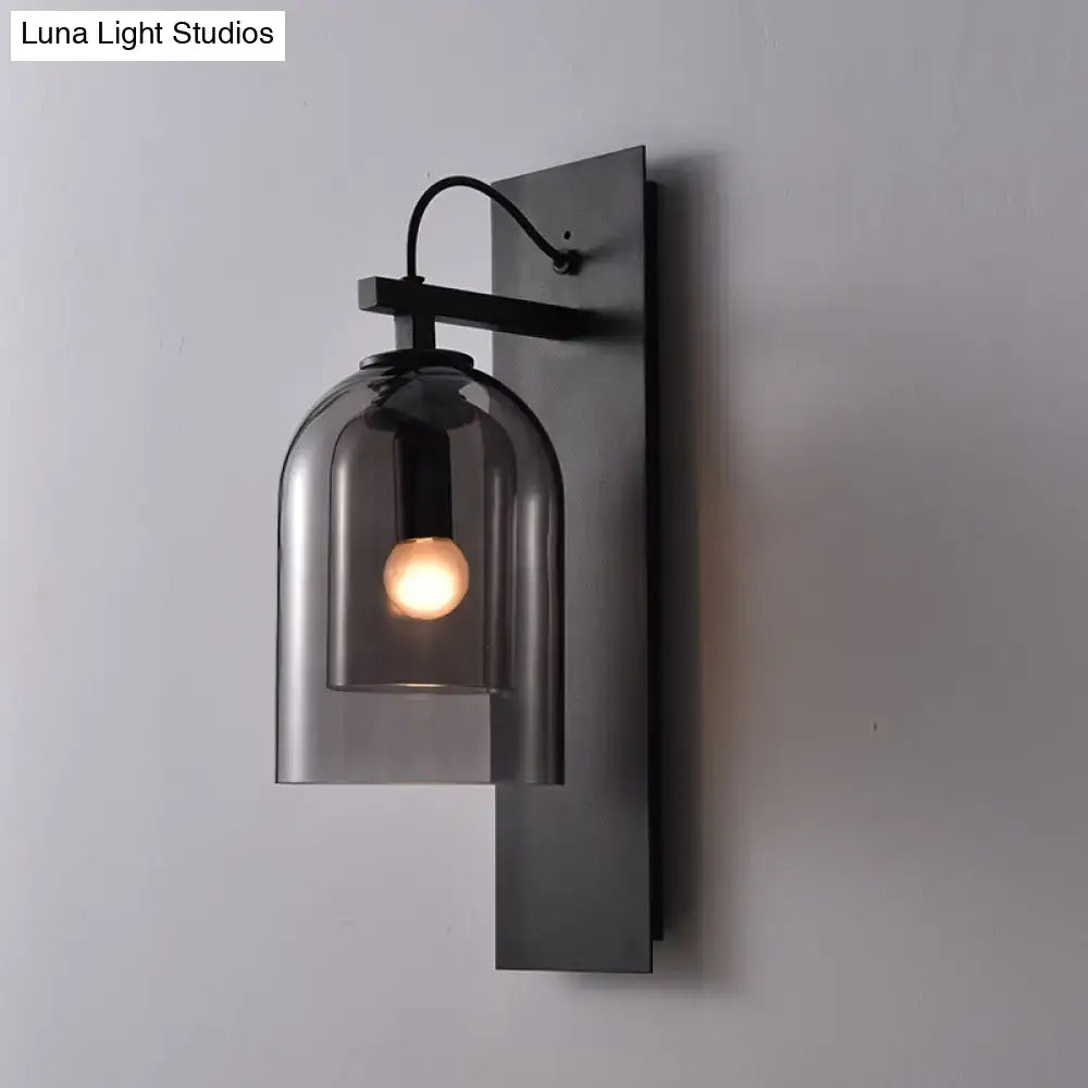 Black metal wall sconce with smoked dome glass shade and exposed bulb, mid-century style for living room use